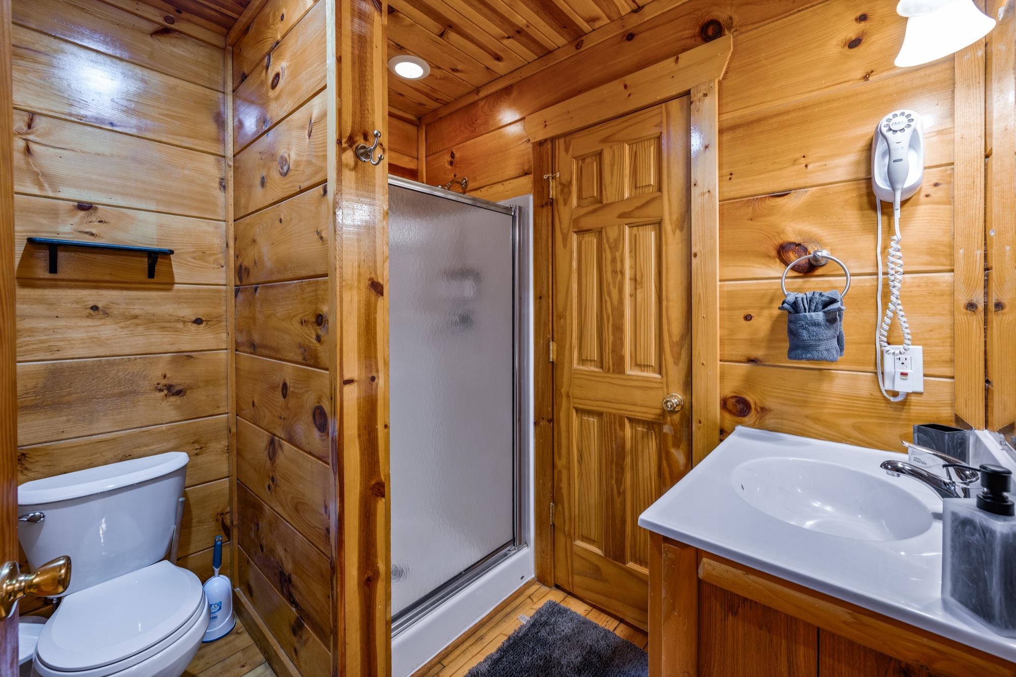 Primary bathroom at Bearadise with a glass shower stall, toilet, and vanity